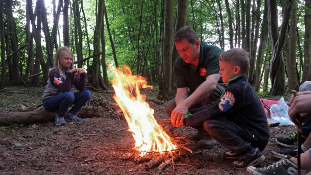 Steve supporting our younger students to safely build and manage their fires.