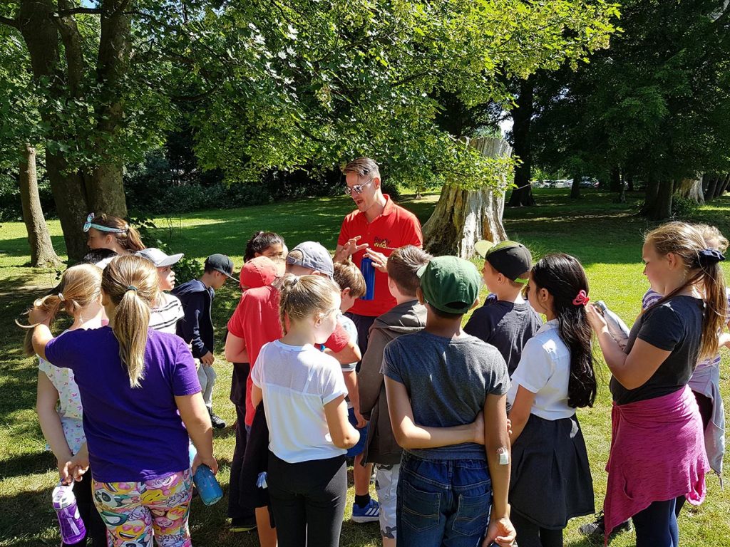 Young People learning about wildlife and surviving from one of the Really Wild Instructors. Nev is describing how important it is to stay hydrated and to keep your water clean and safe.
